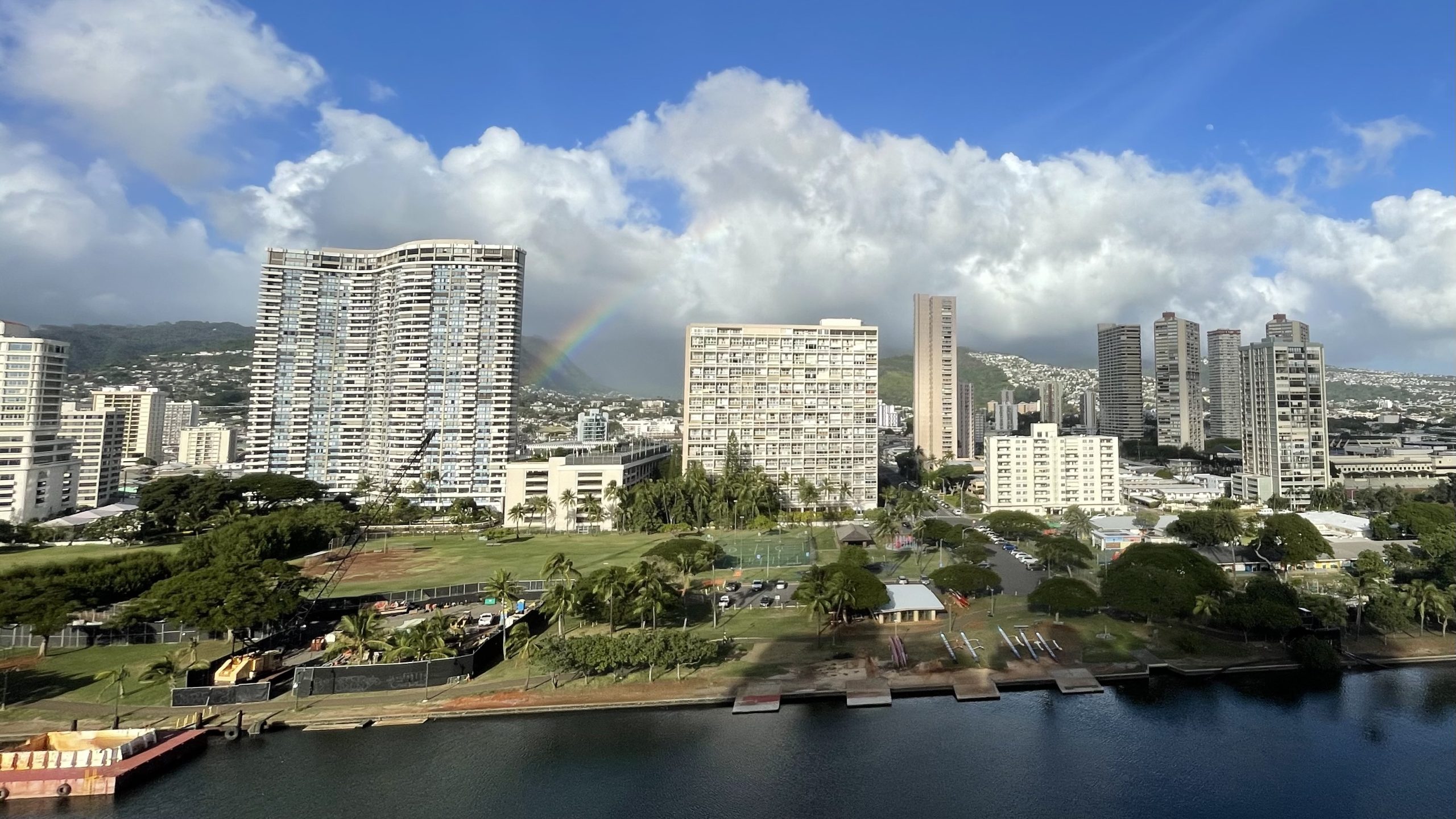 Honolulu condo buildings with a rainbow in the background, illustrating property types common in leasehold vs fee simple in Hawaii.
